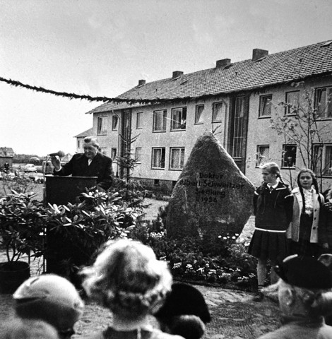 Der Gedenkstein erinnert an den Namensgeber der Siedlung: Der Aufsichtsratsvorsitzender Carl Broschinski hält eine Rede anlässlich der Einweihung der Albert-Schweitzer-Siedlung 1956.